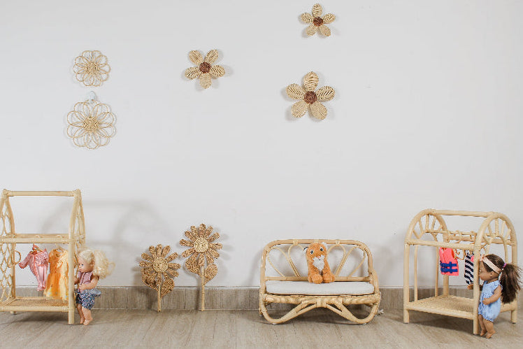 Boho rattan flower wall art displayed above rattan doll furniture in a girls playroom
