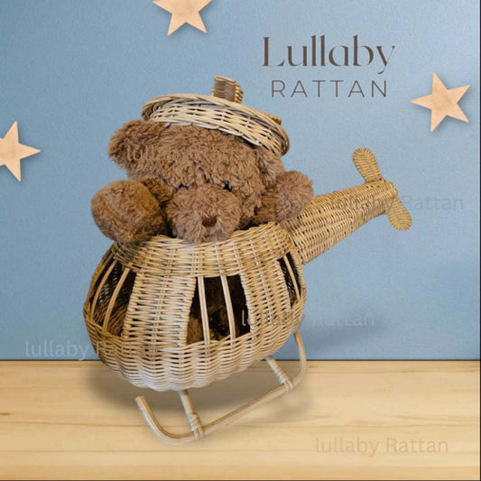 Teddy Bear sits in a rattan made toy helicopter. In the background is a blue wall with stars on it. Good for a child's 1st bday or 2nd bday. Eco-friendly rattan helicopter toy for boys and girls, ideal for boho or Montessori-style playrooms.