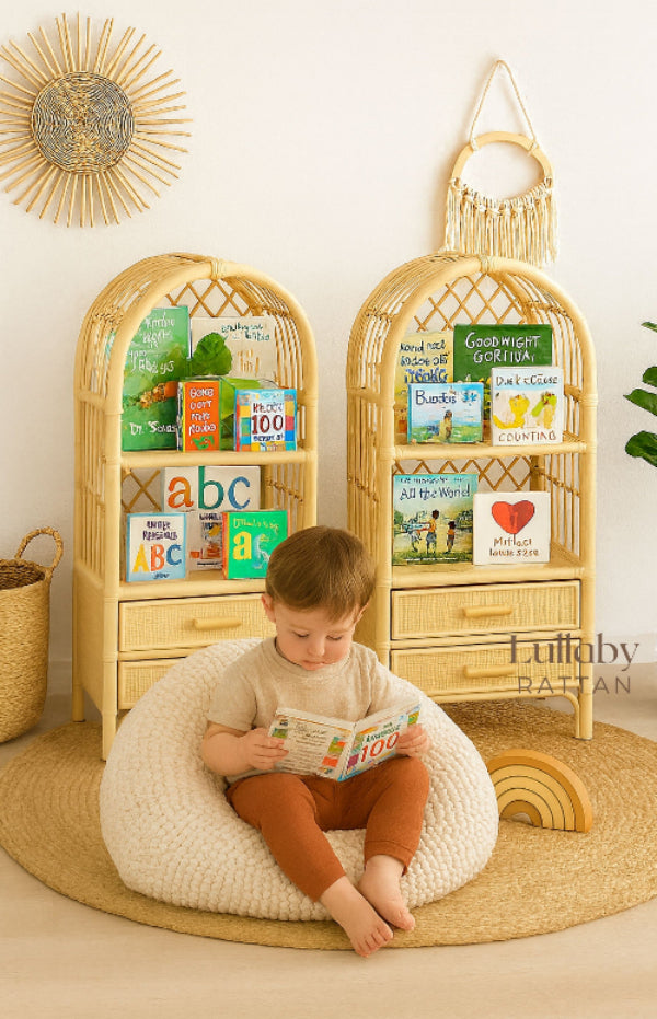 Child sitting on a bean bag reading a book in a room with wicker shelves and decor.