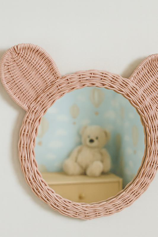 Pink wicker mirror with bear ears featuring a teddy bear in a blue room.
