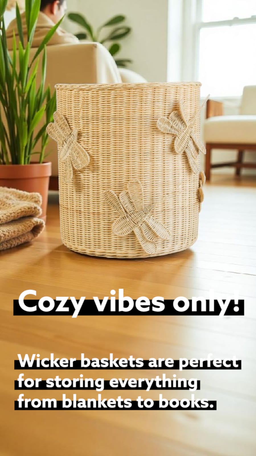 Wicker hamper sits on wooden floor inside minimalist house. A faux plant sits beside it. 