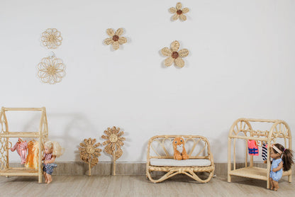 Boho rattan flower wall art displayed above rattan doll furniture in a girls playroom