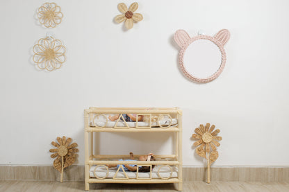 Boho flower wall decor made from rattan displayed in a girls playroom above doll furniture