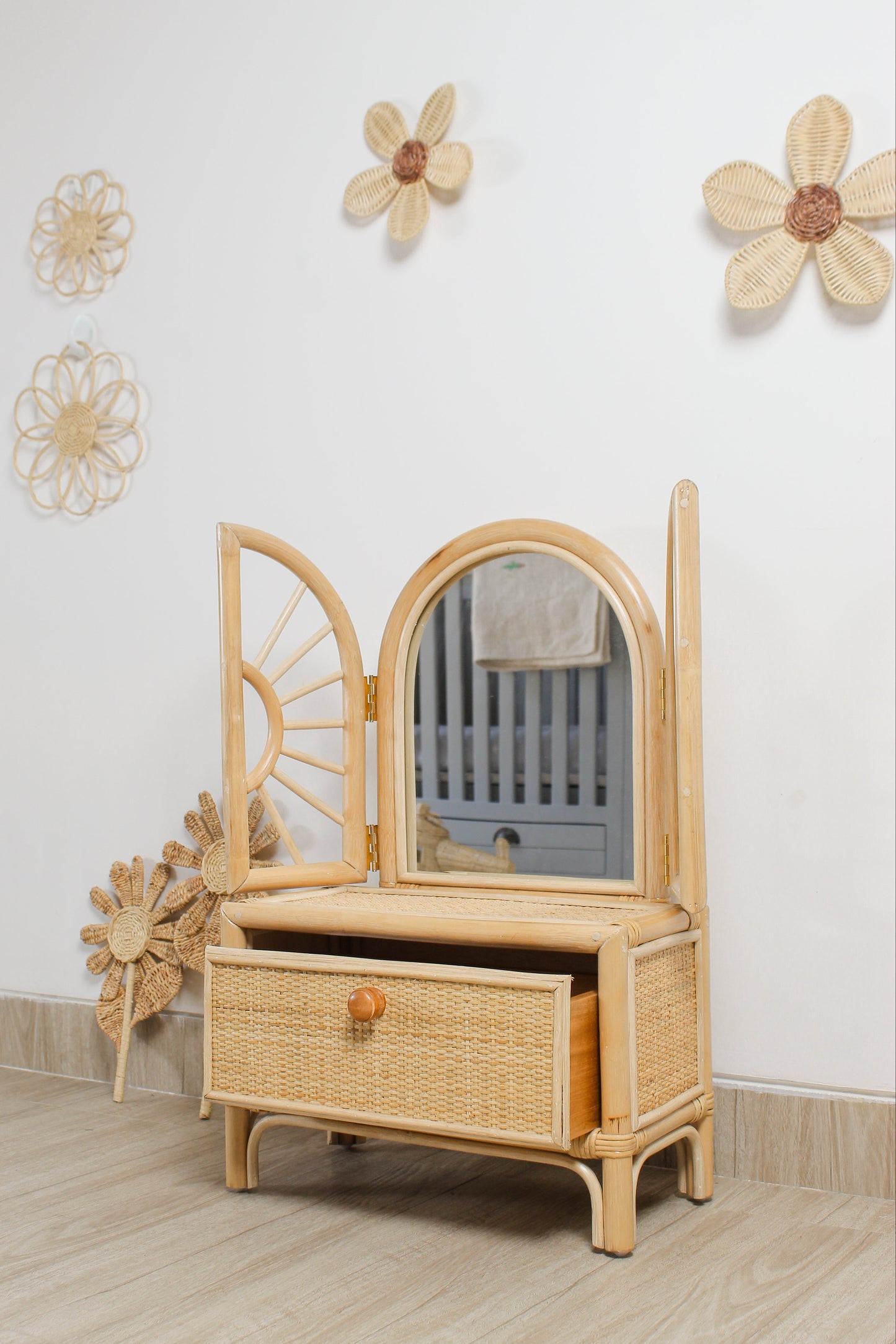 Handmade botanical rattan flower wall decor displayed with rattan toys and doll furniture