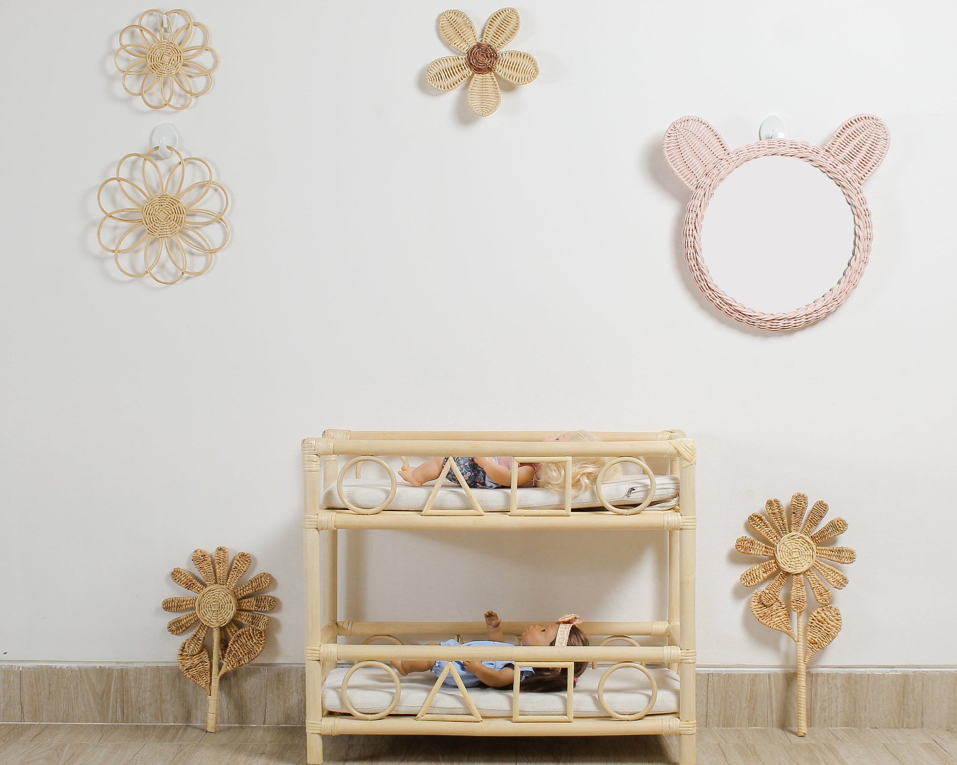 Boho flower wall decor made from rattan displayed in a girls playroom above doll furniture