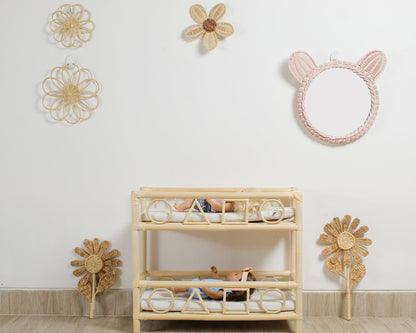 Boho flower wall decor made from rattan displayed in a girls playroom above doll furniture