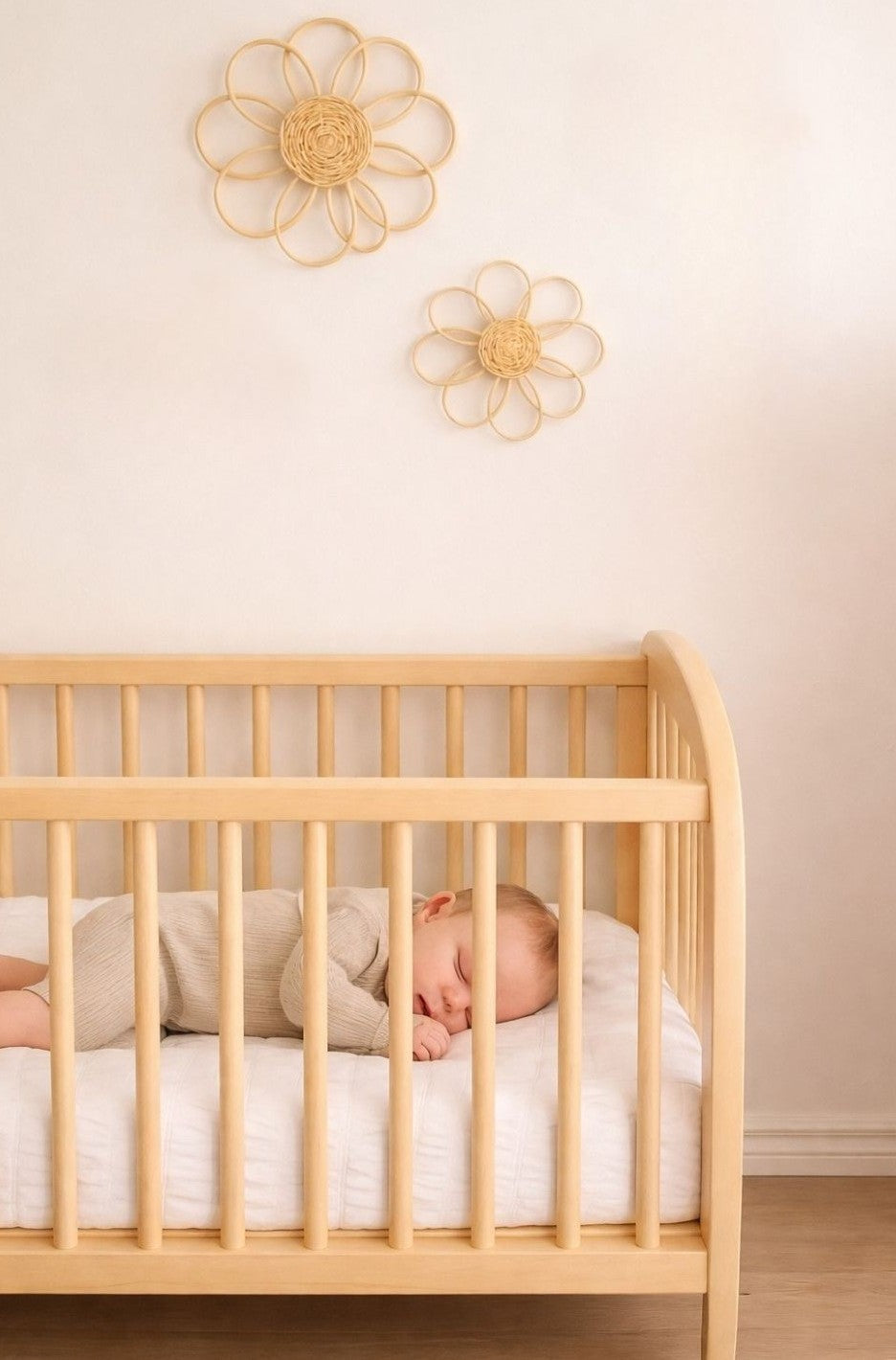 Handmade rattan flower wall decor styled in a soft neutral girls nursery with wooden toys