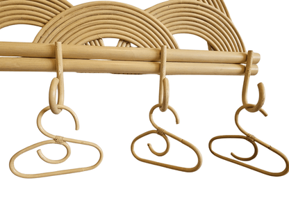 A rattan wall hanger with doll sized coathangers