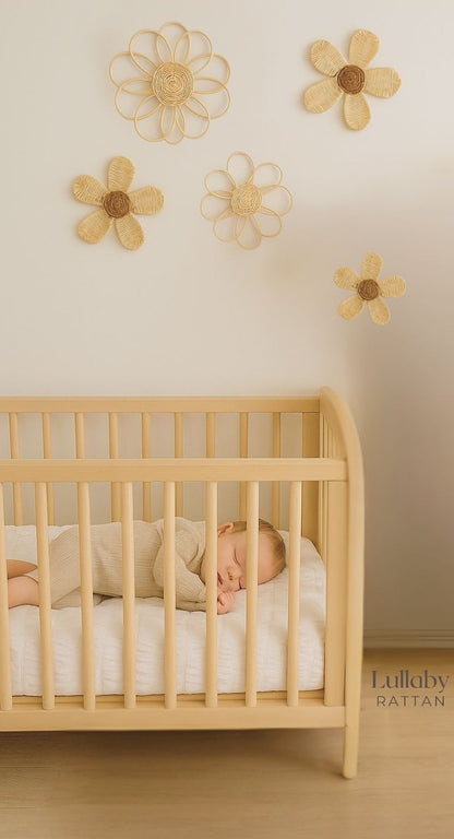 Baby sleeping in a crib with decorative flowers on the wall