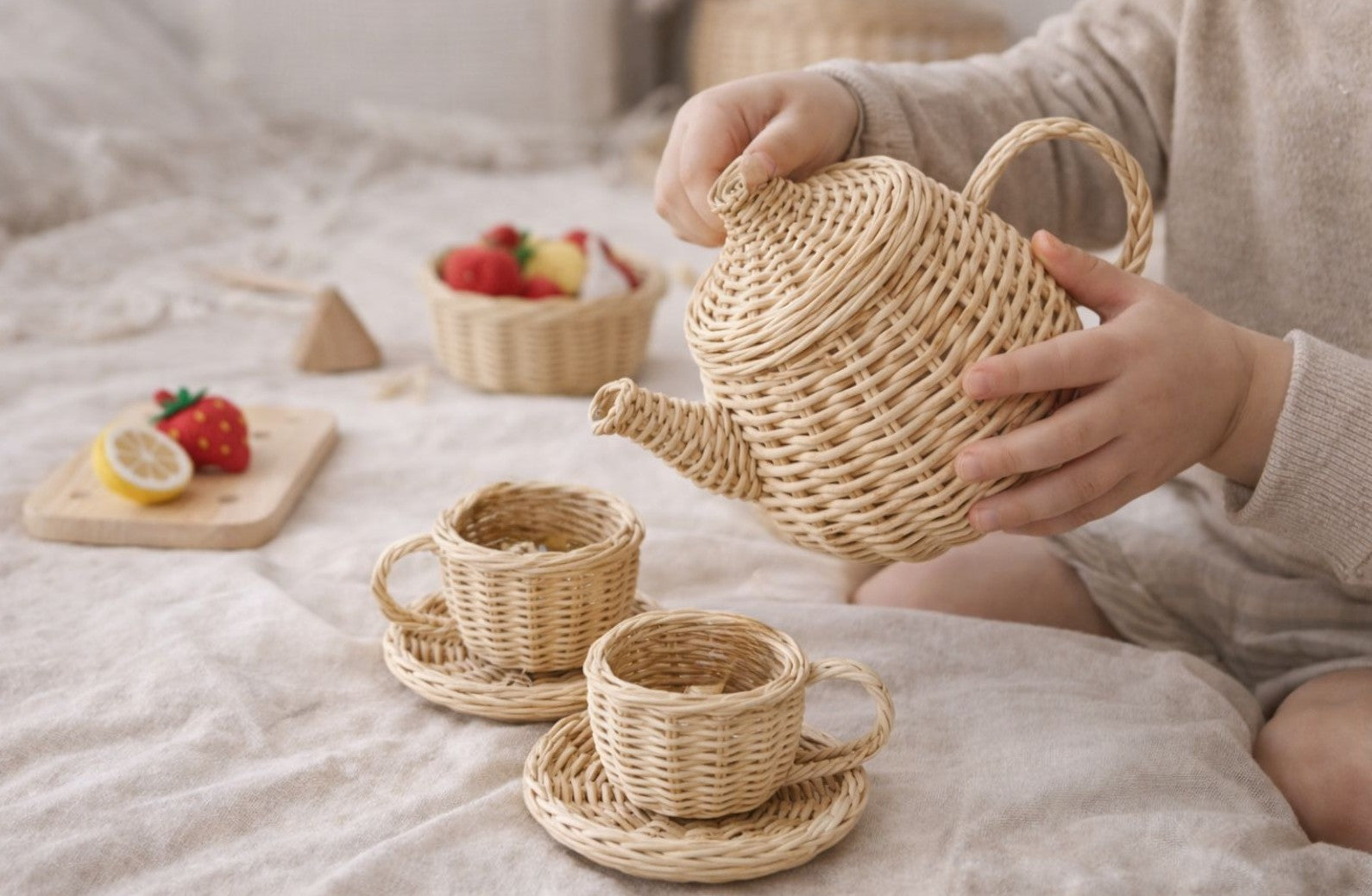 Child playing with a woven tea set on a soft surface