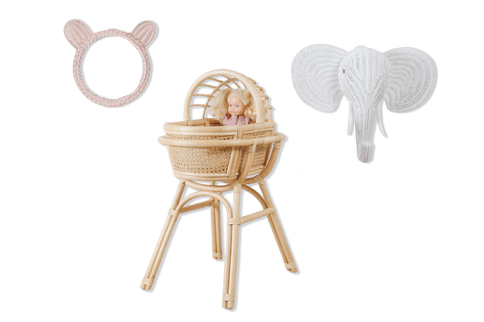 A doll in a rattan made doll play bassinet with an elephant head for decoration and teddy bear wall mirror