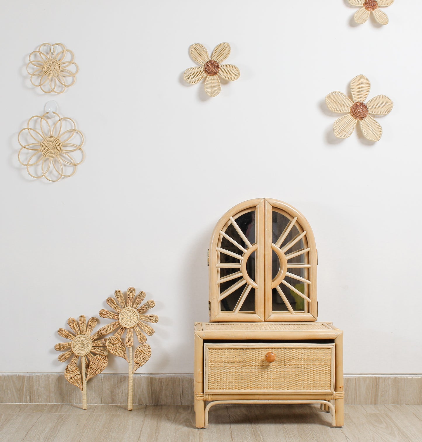 A girls mirror vanity sits by the wall with two cute stem flowers sitting next to it. They are pretty flowers. Wall decor flowers also sit on the wall. Natural kids room. Montessori room. 