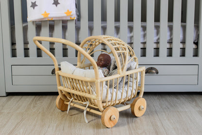 Toy baby carriage with a doll inside on a wooden floor in a nursery.