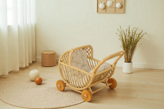 Wicker baby crib with wheels in a room with a plant and rug.