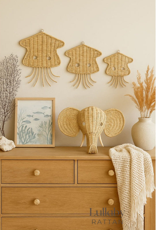 Wicker elephant head on a wooden dresser with wall decorations and a vase. Jellyfish wall decor for ocean apartment or boho vibe