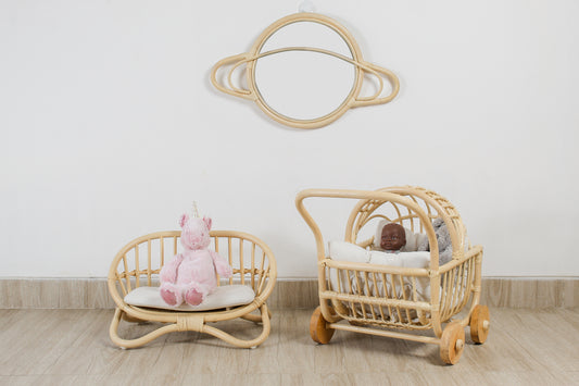 A saturn planet wall mirror sits behind doll toys and accessories. Cosmic kids playroom, space theme toys. 