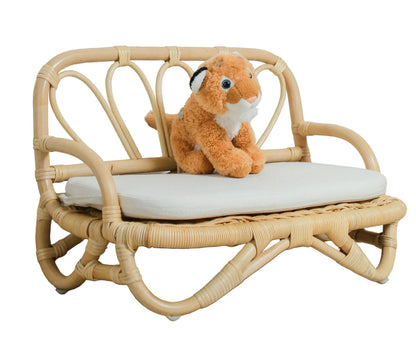 Small wooden bench with a plush toy on a light wooden floor against a white wall.
