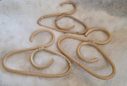 3 coat hangers laying on a cosy sheep skin rug. 