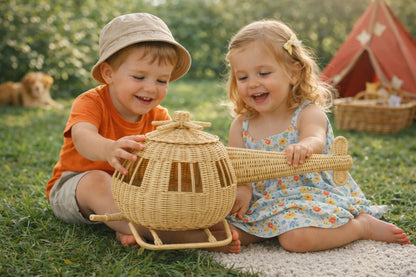 Two children playing with a woven toy airplane outdoors.