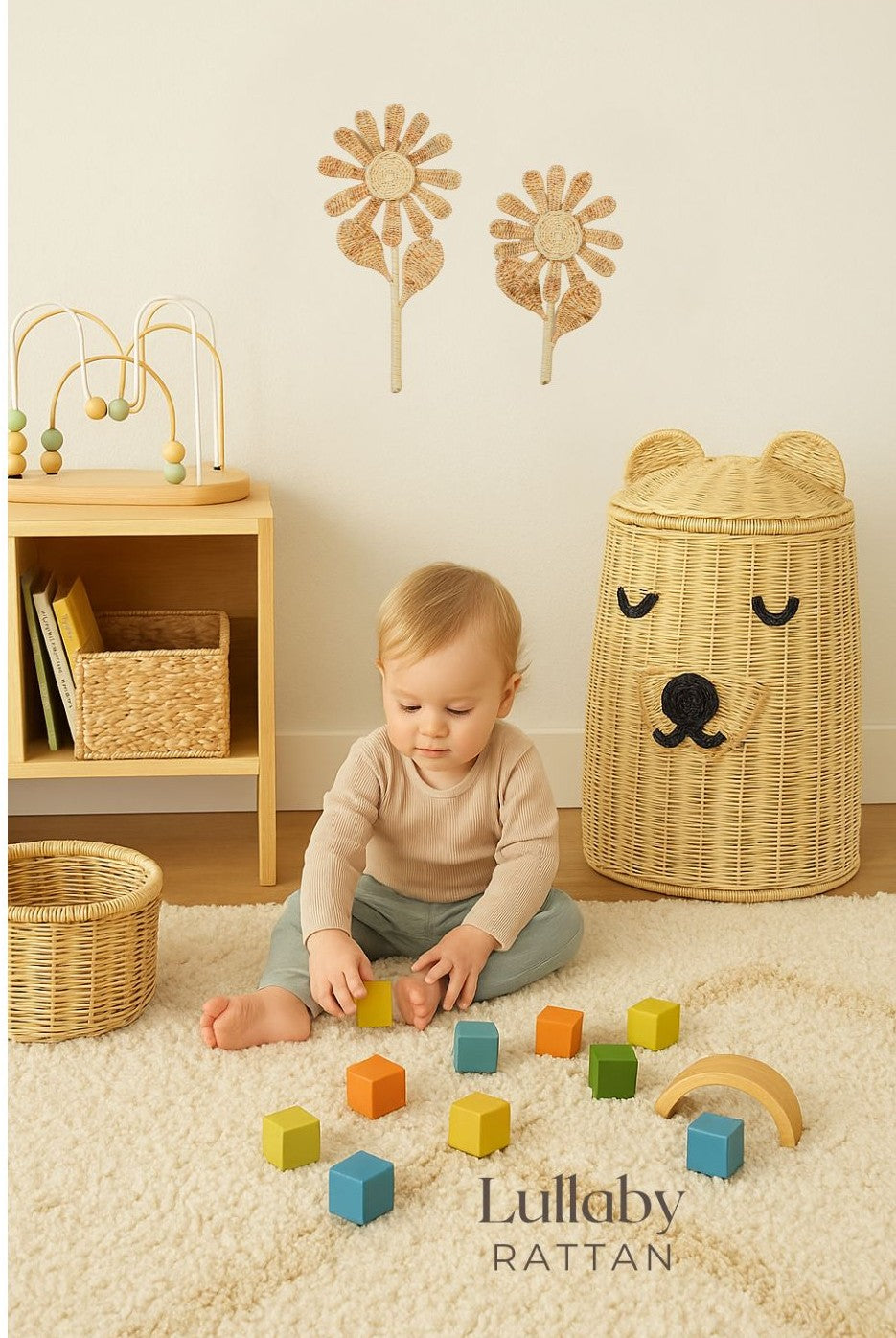 Child playing with colorful blocks on a carpeted floor with wicker furniture and decor. Flower wall decoration. Puppy dog style hamper. Storage basket. 