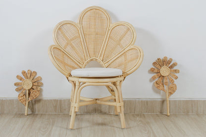 Wicker chair with a cushion on a wooden floor against a white wall. A girls bedroom decorative chair. Flower design. Rattan chair. Flower decoration. 